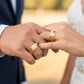 Manos de una pareja usando unas argollas de matrimonio en oro amarillo de 18 quilates de Joyería Caracas. 