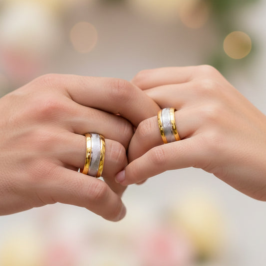 Manos de una pareja usando unas argollas en oro amarillo y blanco de 18 quilates de Joyería Caracas.