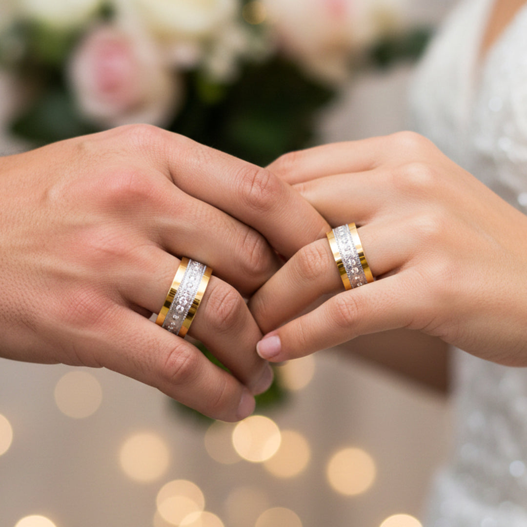 Manos de una pareja usando unas argollas en oro amarillo y blanco de 18 quilates de Joyería Caracas.
