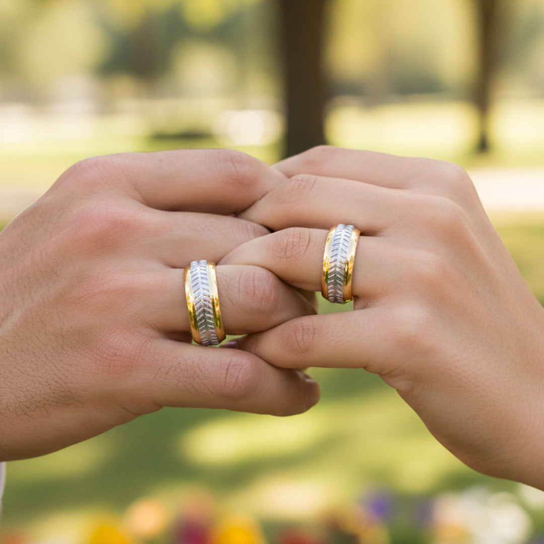 Manos de una pareja usando unas argollas en oro amarillo y blanco de 18 quilates de Joyería Caracas. 