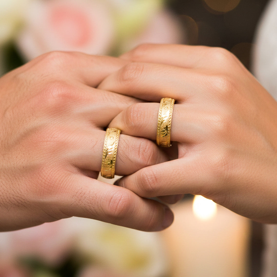 Manos de una pareja usando unas argollas en oro amarillo de 18 quilates de Joyería Caracas.