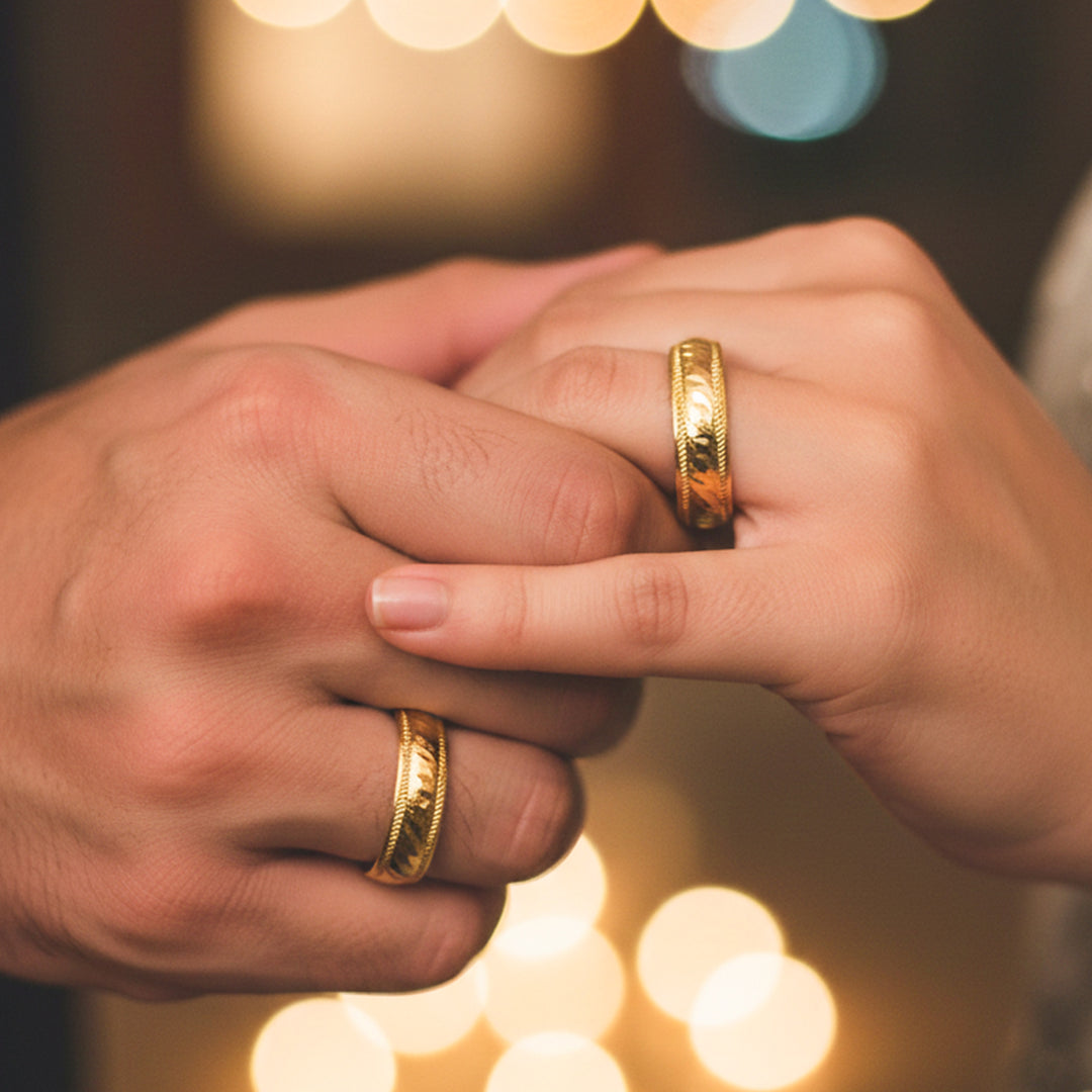Manos de una pareja usando unas argollas en oro amarillo de 18 quilates de Joyería Caracas.