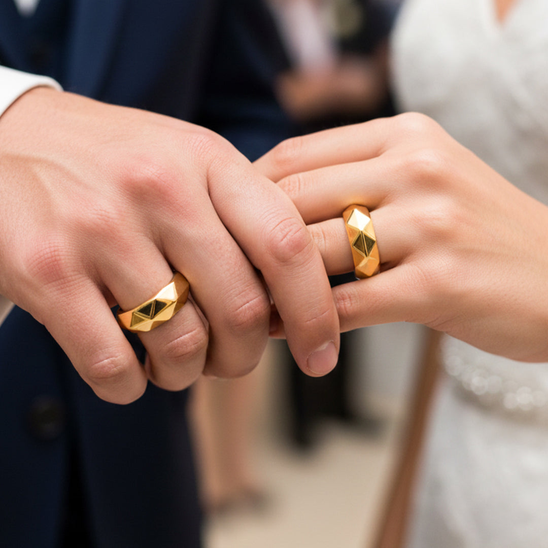 Manos de una pareja usando unas argollas en oro amarillo de 18 quilates de Joyería Caracas. 