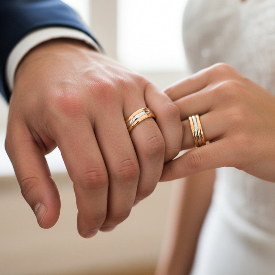 Manos de una pareja usando unas argollas en oro amarillo, blanco y rosa de 18 quilates de Joyería Caracas.