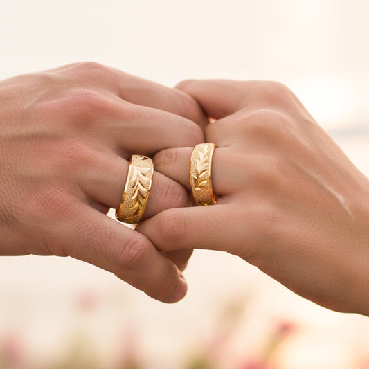 Manos de una pareja usando unas argollas en oro amarillo de 18 quilates de Joyería Caracas.