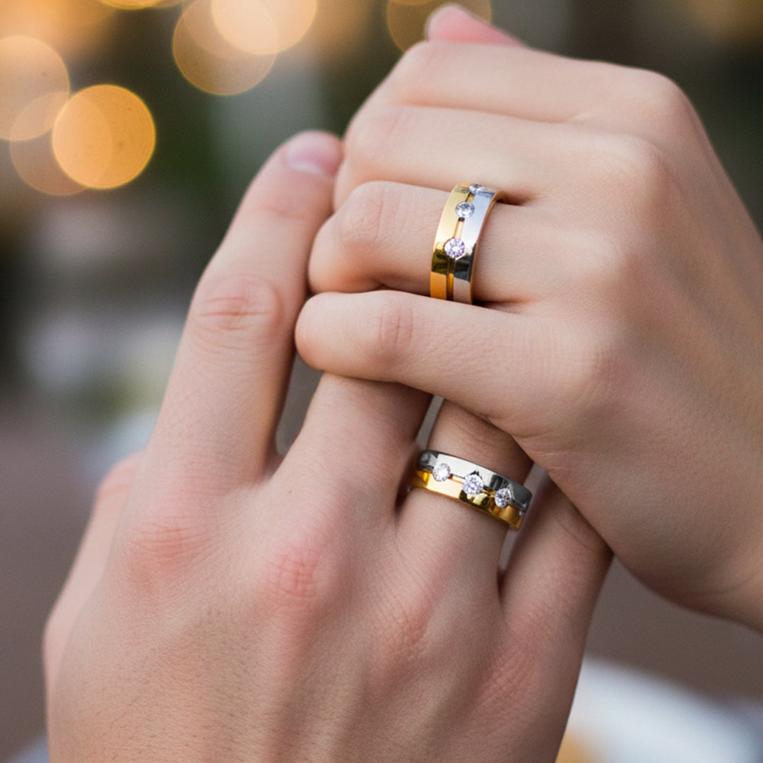 Manos de una pareja usando unas argollas en oro amarillo y blanco de 18 quilates con cristales de Joyería Caracas.