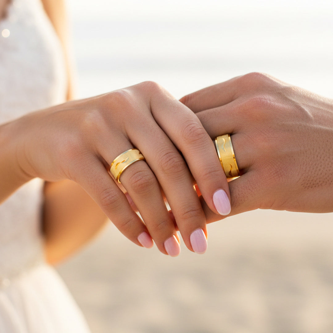 Manos de una pareja usando unas argollas en oro amarillo de 18 quilates de Joyería Caracas. 
