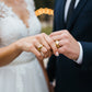Manos de una pareja usando unas argollas de matrimonio en oro amarillo de 18 quilates de Joyería Caracas. 