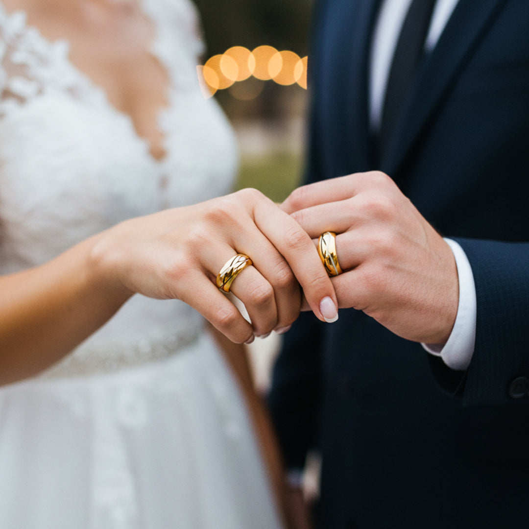 Manos de una pareja usando unas argollas de matrimonio en oro amarillo de 18 quilates de Joyería Caracas. 