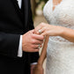 Manos de una pareja usando unas argollas de matrimonio en oro amarillo y blanco de 18 quilates de Joyería Caracas. 