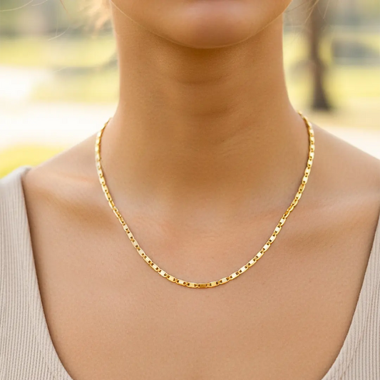 Cuello de modelo usando una cadena en tejido escalera plana espejo en oro amarillo de 18 quilates de Joyería Caracas.