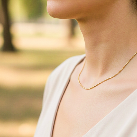Cuello de modelo usando una cadena en tejido militar en oro amarillo de 18 quilates de Joyería Caracas.