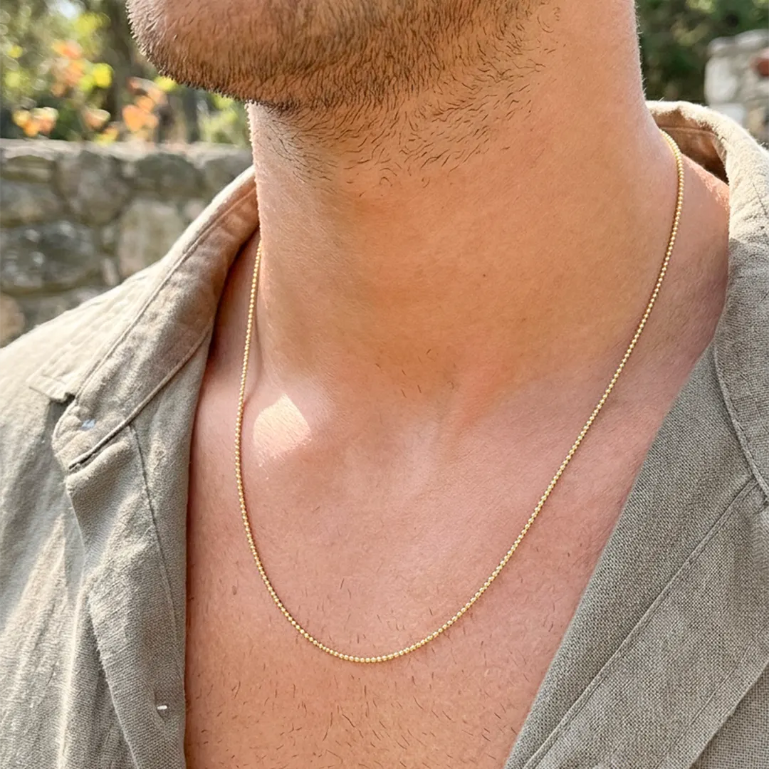 Cuello de modelo usando una cadena en tejido militar en oro amarillo de 18 quilates de Joyería Caracas.