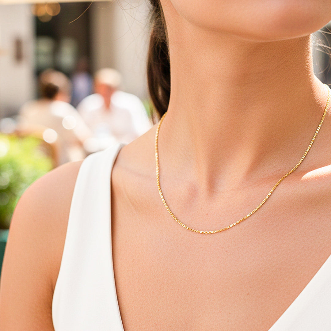 Cuello de modelo usando una cadena en tejido skinny en oro amarillo de 18 quilates de Joyería Caracas.