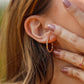 Oreja de mujer usando unas candongas de esferas diamantadas de oro amarillo, blanco y rosa de 18 quilates de Joyería Caracas. 