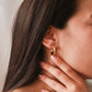 Oreja de mujer usando candongas square en oro amarillo de 18 quilates de Joyería Caracas.
