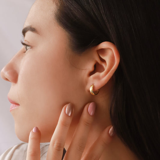Oreja de mujer usando una candonga diamantada en oro amarillo de 18 quilates de Joyería Caracas.