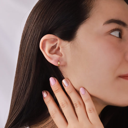 Oreja de mujer usando candongas diamantadas en oro amarillo de 18 quilates de Joyería Caracas.