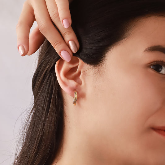 Oreja de mujer usando candonga diamantada en oro amarillo de 18 quilates de Joyería Caracas.