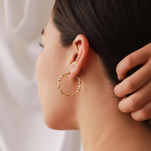 Oreja de mujer usando candonga en forma de melcocha en oro amarillo de 18 quilates de Joyería Caracas.