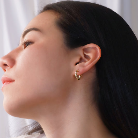 Oreja de mujer usando candongas en forma de melcocha en oro amarillo de 18 quilates de Joyería Caracas.