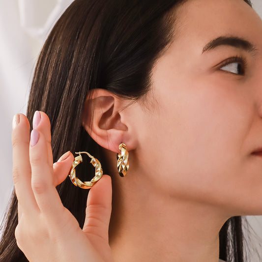 Oreja de mujer usando candonga en forma de melcocha en oro amarillo de 18 quilates de Joyería Caracas.