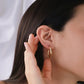 Oreja de mujer usando candonga en forma de melcocha clásica en oro amarillo de 18 quilates de Joyería Caracas.