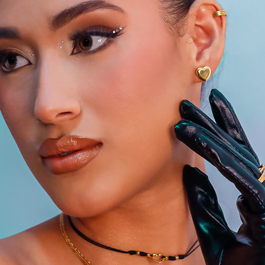 Cuello de mujer usando un chocker en hilo negro con accesorios de mini esferas y herraje en forma de corazón en oro amarillo de 18 quilates de Joyería Caracas. 