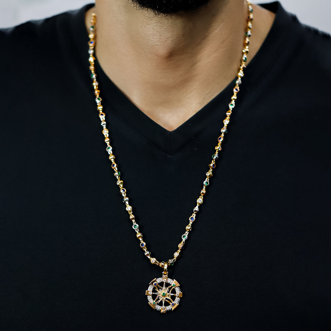 Cuello de hombre con cadena y dije en forma de brújula escualizable en oro amarillo, blanco y rosa de 18 quilates con piedras de color azul, blanco y verde, hecho en Joyería Caracas. 