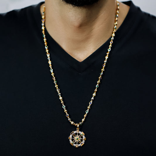Cuello de hombre con cadena y dije en forma de brújula escualizable en oro amarillo, blanco y rosa de 18 quilates con piedras de color azul, blanco y verde, hecho en Joyería Caracas. 