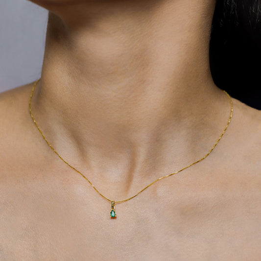 Cuello de mujer con cadena y dije en forma de gota en oro amarillo de 18 quilates con esmeralda en forma de gota, hecho en Joyería Caracas. 