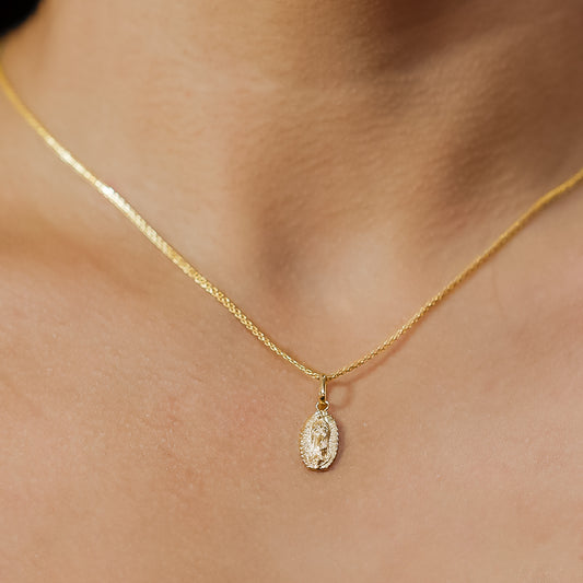 Cuello de mujer con cadena y dije de la Virgen de Guadalupe en oro amarillo de 18 quilates, hecho en Joyería Caracas. 