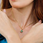 Cuello de mujer con cadena y dije en forma de corazón en oro amarillo de 18 quilates, esmeralda en forma de corazón y diamantes alrededor de color blanco, hecho en Joyería Caracas. 