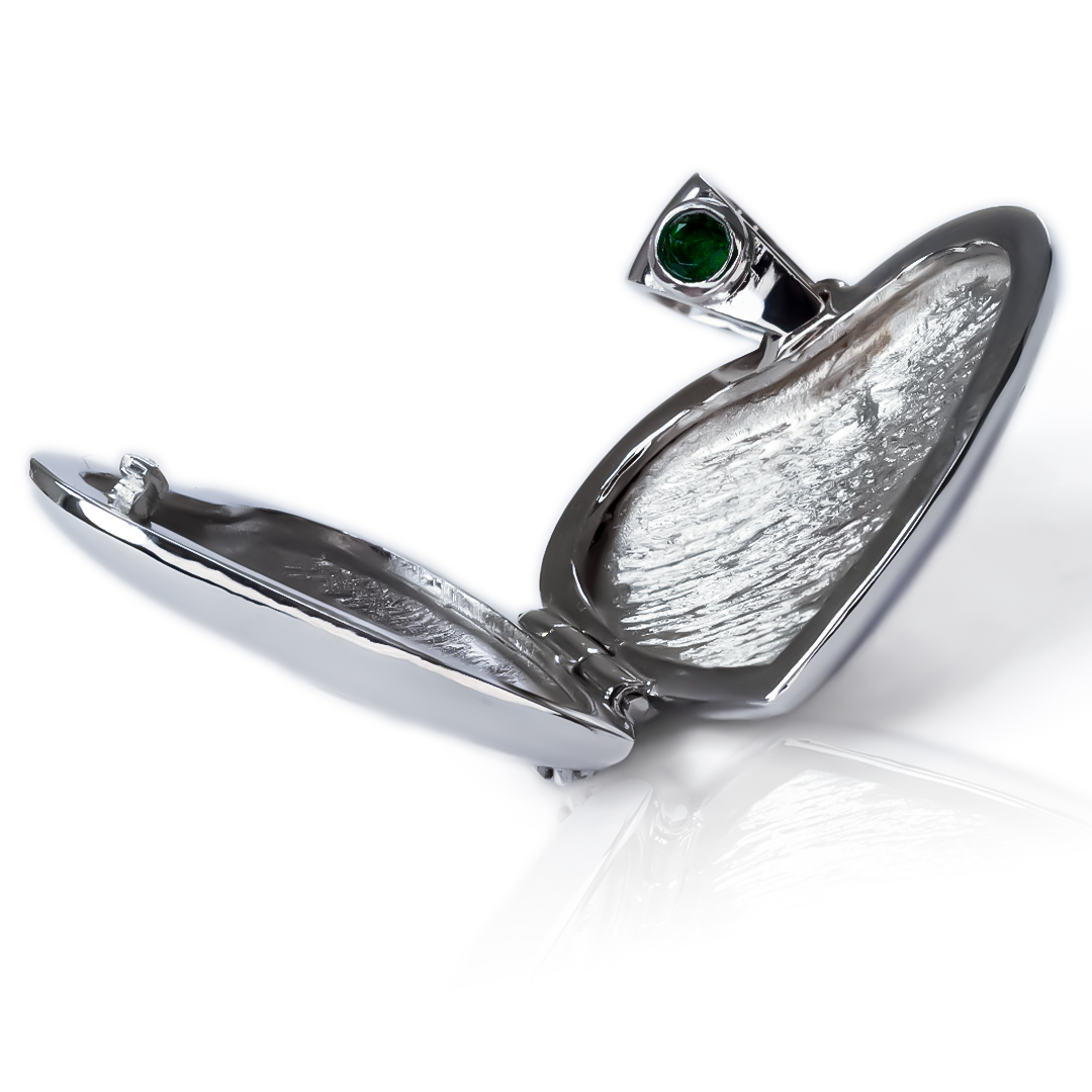 El Dije Relicario corazón de oro de 18K es una joya de la exclusiva Joyería Caracas. Con una preciosa esmeralda y diamantes, esta pieza elegante y sofisticada es una garantía de por vida. Luce con estilo y distinción con este símbolo de amor y lujo.