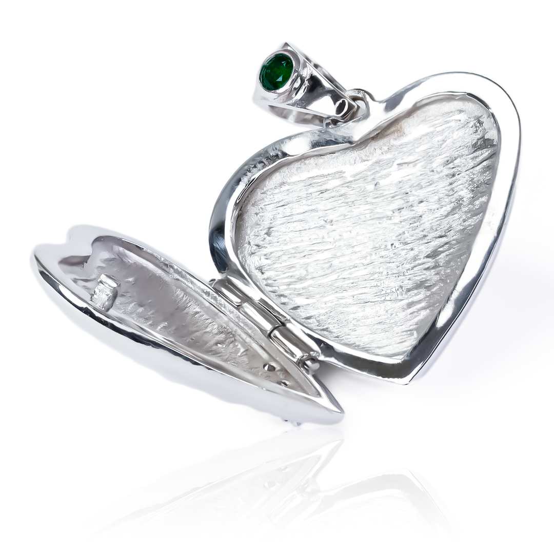 El Dije Relicario corazón de oro de 18K es una joya de la exclusiva Joyería Caracas. Con una preciosa esmeralda y diamantes, esta pieza elegante y sofisticada es una garantía de por vida. Luce con estilo y distinción con este símbolo de amor y lujo.