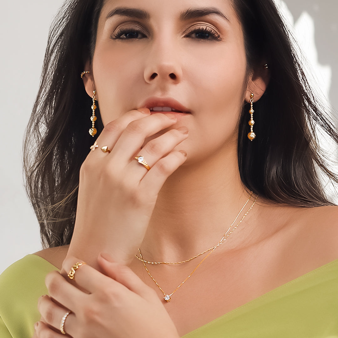 Cuello de mujer con cadena y dije pasante en oro amarillo de 18 quilates con cristal de color blanco, hecho en Joyería Caracas. 