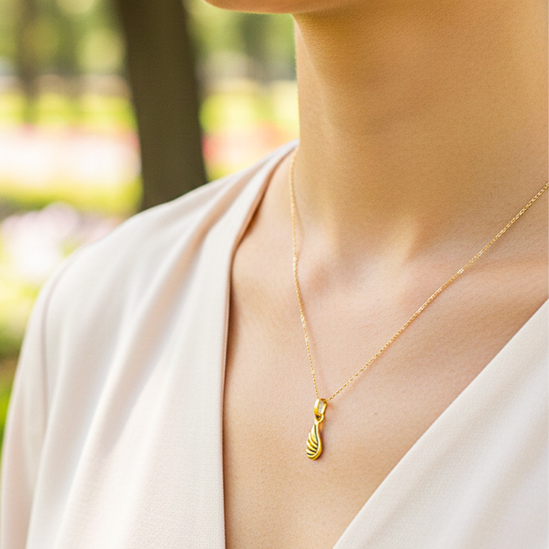 Cuello de modelo usando una cadena con un dije en forma de corazón con angelito en oro amarillo de 18 quilates de Joyería Caracas.