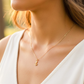 Cuello de modelo usando una cadena con un dije en forma de ancla en oro amarillo de 18 quilates de Joyería Caracas.