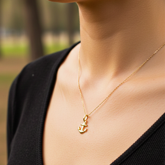 Cuello de modelo usando una cadena con un dije en forma de ancla en oro amarillo de 18 quilates de Joyería Caracas.