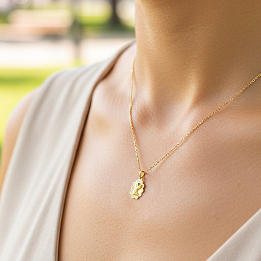 Cuello de modelo usando una cadena con un dije en forma de nube con angelito en oro amarillo de 18 quilates de Joyería Caracas.