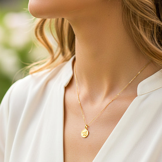 Cuello de modelo usando una cadena con un dije en forma de placa con angelito en oro amarillo de 18 quilates de Joyería Caracas.