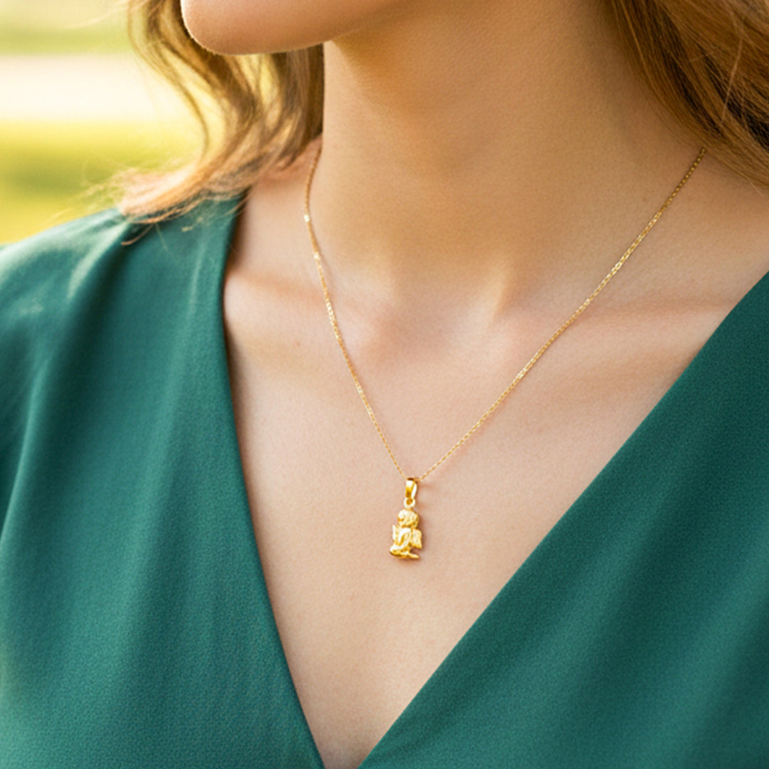 Cuello de modelo usando una cadena con un dije en forma de ángel rezando en oro amarillo de 18 quilates de Joyería Caracas.