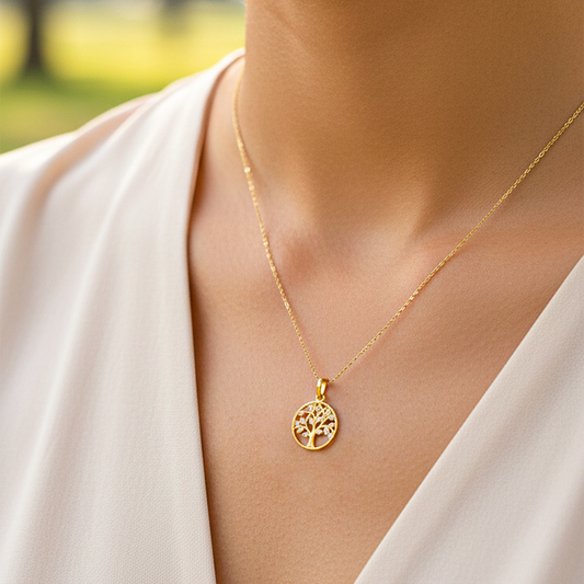 Cuello de modelo usando una cadena con un dije en forma de árbol en oro amarillo de 18 quilates con cristales de Joyería Caracas.