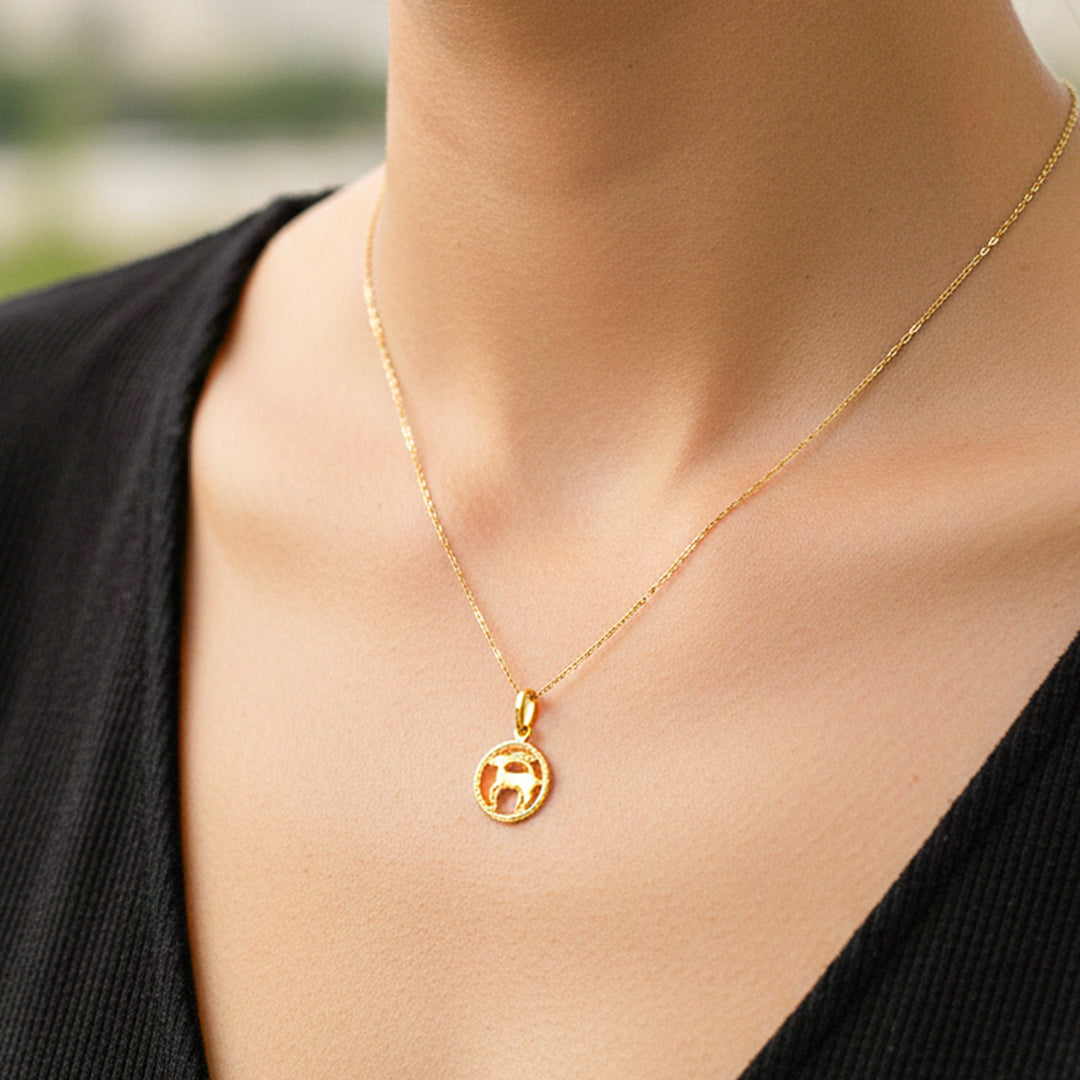 Cuello de modelo usando una cadena con un dije en forma del signo zodiacal de Aries en oro amarillo de 18 quilates de Joyería Caracas.