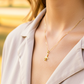 Cuello de modelo usando una cadena con un dije en forma de avión en oro amarillo de 18 quilates de Joyería Caracas.
