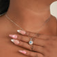 Cuello de mujer con cadena y dije en oro blanco de 18 quilates con Diamante central de color celeste y Diamantes de color blanco alrededor. 