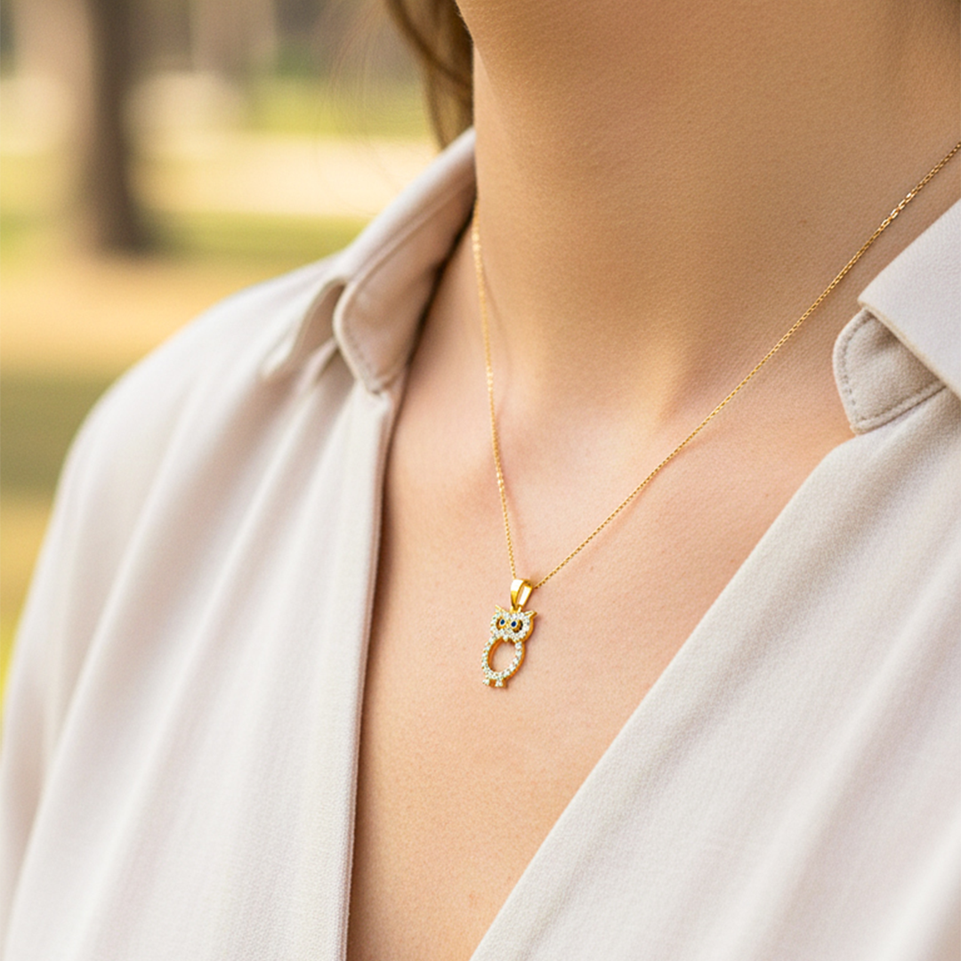 Cuello de modelo usando una cadena con un dije en forma de Búho en oro amarillo de 18 quilates con cristales de Joyería Caracas.