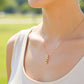 Cuello de modelo usando una cadena con un dije en forma de gato en oro amarillo de 18 quilates con cristales de Joyería Caracas.
