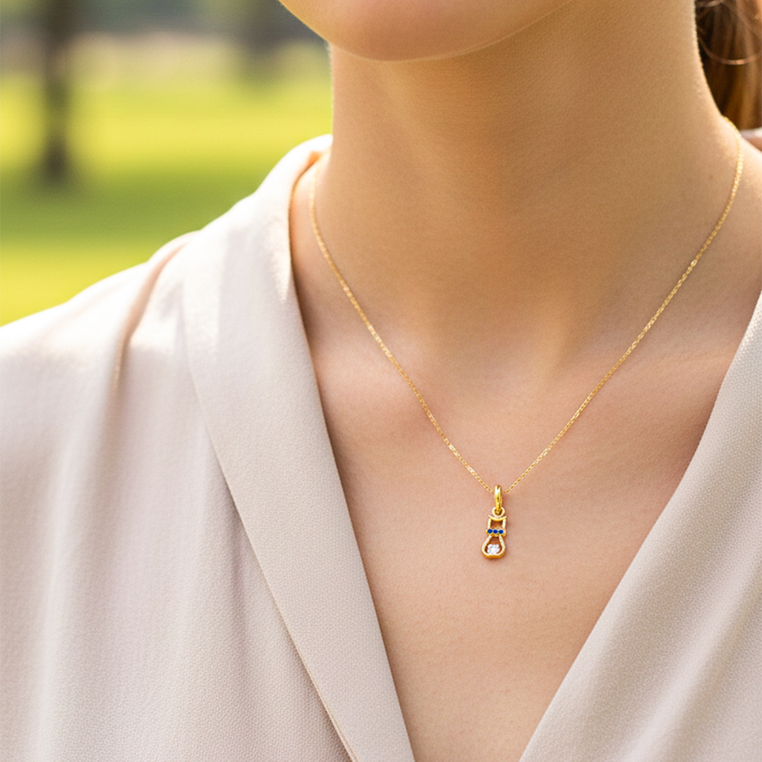 Cuello de modelo usando una cadena con un dije en forma de gato en oro amarillo de 18 quilates con cristales rojos de Joyería Caracas.