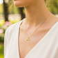 Cuello de modelo usando una cadena con un dije en forma de cola de sirena en oro amarillo de 18 quilates de Joyería Caracas.